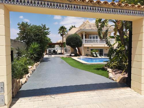 Villa with serene mountain views. Spacious garden with 10x5m pool. في فورتونا: ممر يؤدي إلى منزل مع مسبح