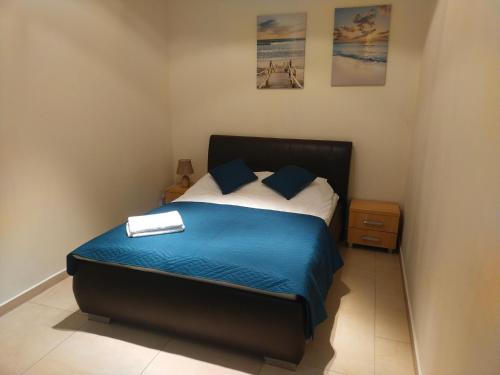 een slaapkamer met een bed met een blauwe deken en kussens bij Apartament Przy Parku Wisełka in Wisełka