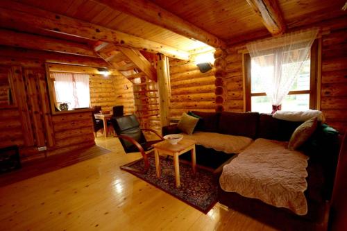 a living room with a couch in a log cabin at Milanova koliba Zlatar in Nova Varoš
