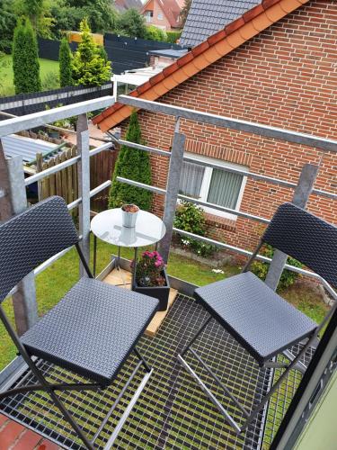 eine Terrasse mit 2 Stühlen und einem Tisch auf dem Balkon in der Unterkunft Apartment am Obenende in Papenburg