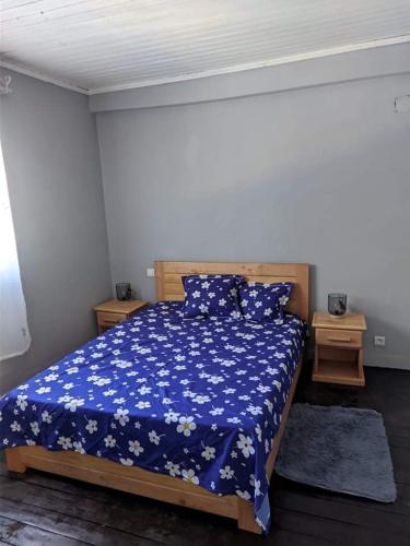 1 Schlafzimmer mit einem Bett mit blauer Decke und 2 Tischen in der Unterkunft Villa Emma Ampefy 