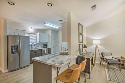 a kitchen with a stainless steel refrigerator and a table at Cozy-Modern Pensacola Home Large Yard, Grill in Pensacola
