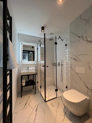 a bathroom with a shower and a toilet and a sink at NEON APARTMENTS in Sopot