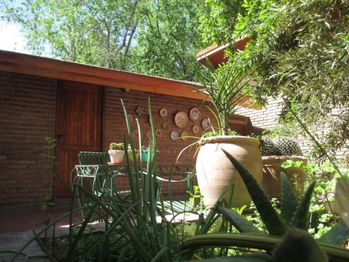 a patio with a table and chairs in a garden at Lujan De Cuyo B&B in Ciudad Lujan de Cuyo