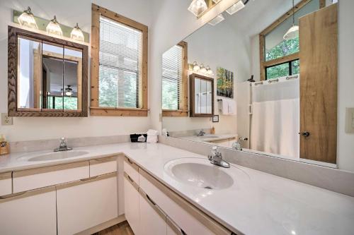 a white bathroom with two sinks and a mirror at Mountain Views and Deck Spacious Bryson City Home! in Bryson City