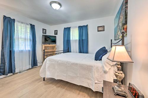 a bedroom with a bed and blue curtains at Greensboro Home Less Than 4 Mi to Downtown! in Greensboro