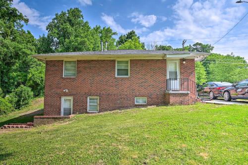 a brick house on a hill with a yard at Greensboro Home Less Than 4 Mi to Downtown! in Greensboro