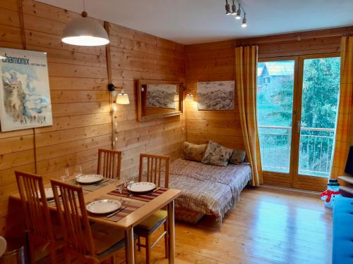 - une salle à manger avec une table et un lit dans une chambre dans l'établissement Studio centre station AURON 4 personnes WIFI, à Auron