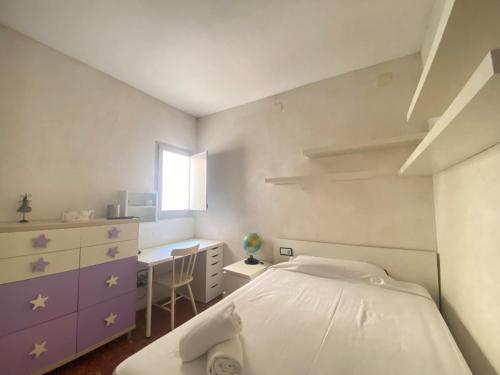 1 dormitorio con cama, escritorio y ventana en R135 Apartamento Playa, en Calafell