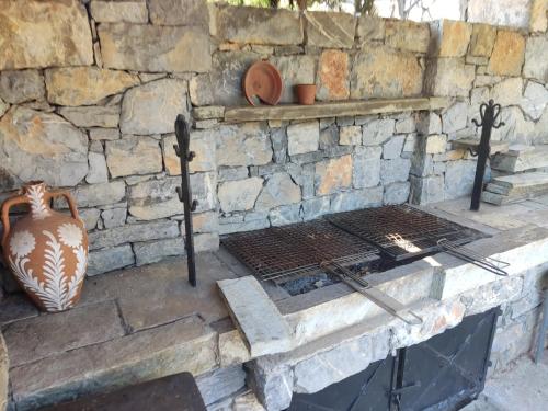 a stone fireplace with a vase on top of it at Lito's dream villa by the sea! in Amaliápoli