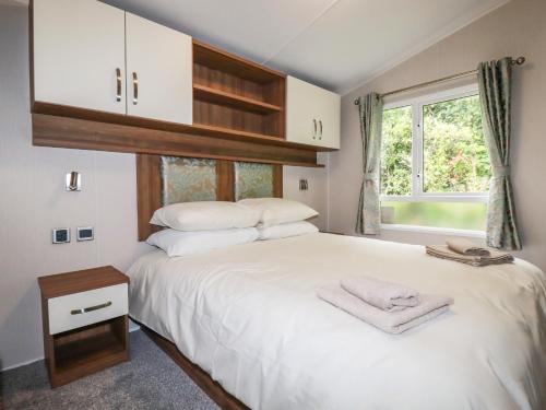 Un dormitorio con una gran cama blanca y una ventana en 205 The Meadows, en Newquay