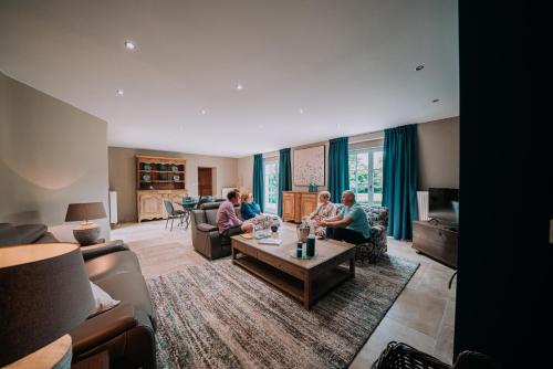 a group of people sitting in a living room at Cour 44 - Gite de charme avec sauna et jacuzzi in Remicourt