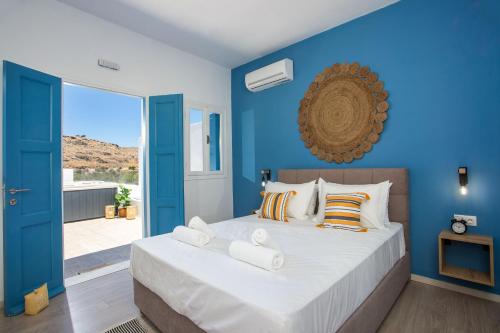 a bedroom with blue walls and a bed with pillows at Villa Euphrosyne in Líndos
