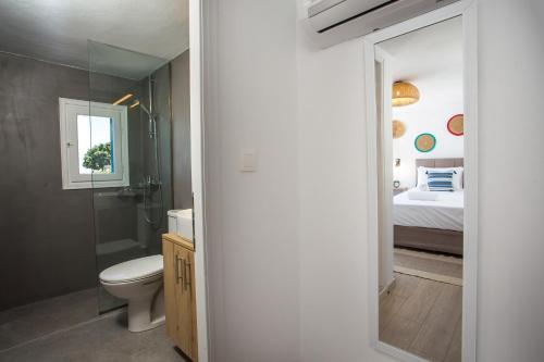 uma casa de banho com WC e um quarto com cama em Villa Euphrosyne em Lindos
