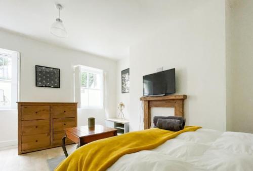 a bedroom with a bed and a tv on the wall at Pittville Studios - By Suitely in Cheltenham
