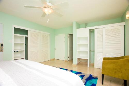 a bedroom with a bed and a ceiling fan at Diamond Gem Residence in Koolbaai