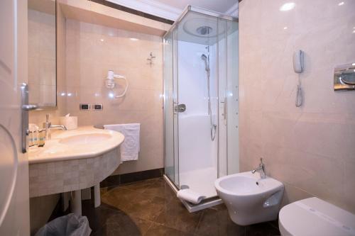 a bathroom with a shower and a sink and a toilet at Hotel Regina Margherita in Cagliari