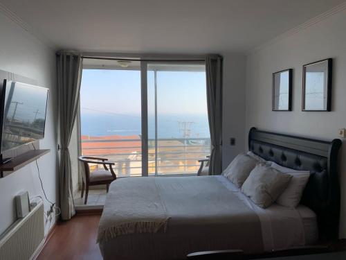 a bedroom with a bed with a view of a balcony at Departamento studio con exquisita vista in Viña del Mar