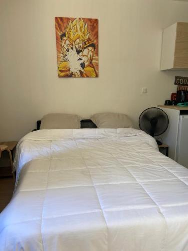 - un lit blanc dans une chambre ornée d'une peinture murale dans l'établissement Studio moderne & fonctionnel, à Marseille