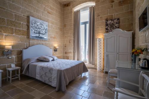 a bedroom with a bed and a brick wall at Corte Fantasia in Triggianello