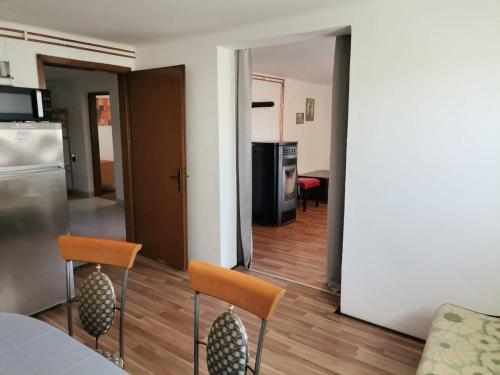a living room with two chairs and a kitchen at Appartement Drava 1 in Donja Dubrava