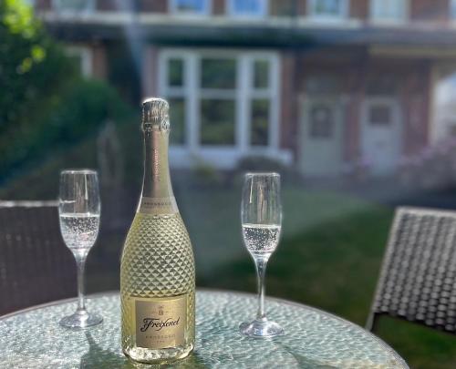 uma garrafa de champanhe e dois copos numa mesa em 34Three em Lytham St Annes