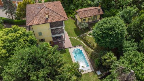 einen Blick über ein Haus mit Pool in der Unterkunft L'Ortensia della Villa Isabella, Camera con vista lago, balcone sul parco e bagno esclusivo all'esterno della camera in Stresa