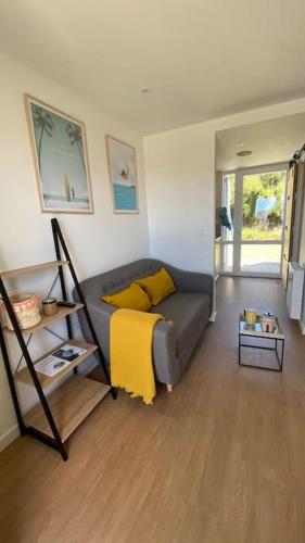 - un salon avec un canapé et une couverture jaune dans l'établissement Studio duplex face à la mer, à Guidel