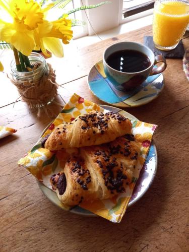 a plate with two pieces of food and a cup of coffee at Hebble End View B&B in Hebden Bridge