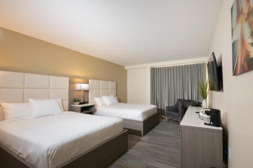 a hotel room with two beds and a television at Apache Gold Resort Hotel & Casino in Globe