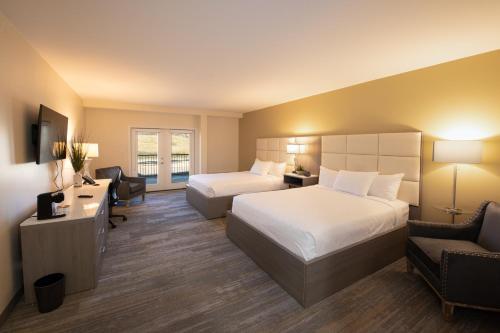 a hotel room with two beds and a desk at Apache Gold Resort Hotel & Casino in Globe