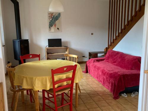 uma sala de estar com uma mesa e um sofá em Orchidée 1 et 2_ départ de randonnées em Mariac