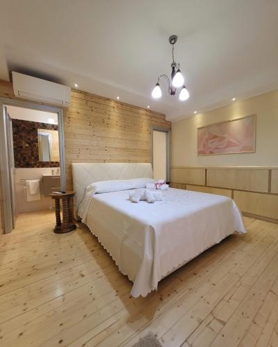 a bedroom with a large white bed and a bathroom at ArcHome in Pompei