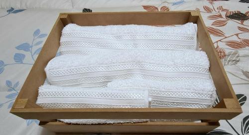 Una caja de toallas blancas sentadas en una cama en SOYSOL.DEPARTAMENTOS en San Salvador de Jujuy