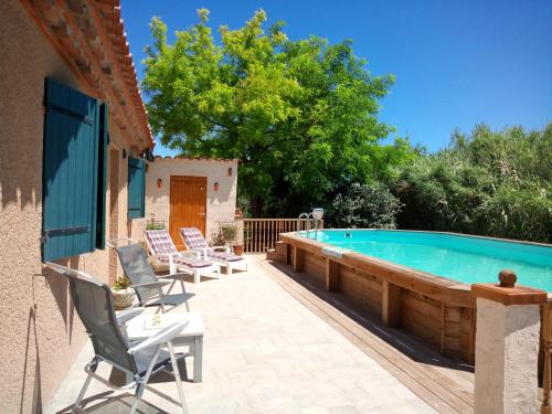 - une piscine avec une terrasse et des chaises à côté d'une maison dans l'établissement Olive View, à Puissalicon