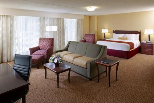 a hotel room with a bed and a couch at Clinton Inn Hotel Tenafly in Tenafly