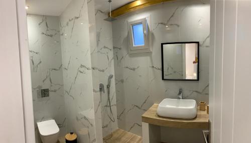 a white bathroom with a sink and a shower at il Centro in Ios Chora