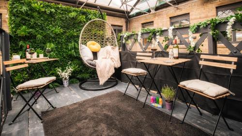 a patio with two tables and chairs and a swing at Stunning 2 bed with outside balcony, super king beds and 75’’ TV! in Bradford
