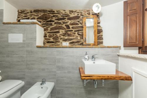 a bathroom with a sink and a stone wall at Bed and Terrace Caterina in Baunei