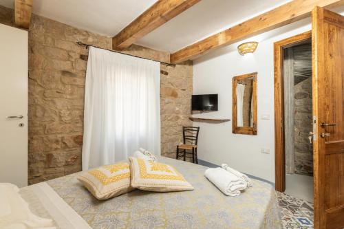 a bedroom with a bed with two pillows on it at Bed and Terrace Caterina in Baunei