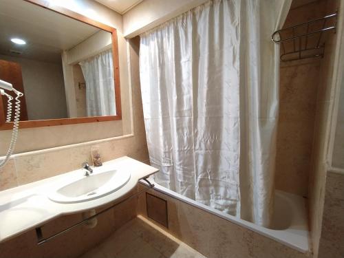 uma casa de banho com um lavatório, um chuveiro e um espelho. em APARTAMENTO VISTAS LATERALES AL MAR SEGUNDA PLANTA em Isla Canela