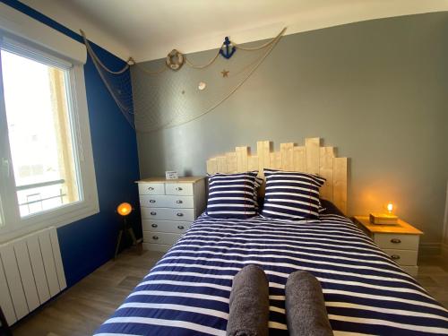 une chambre avec un lit à rayures bleues et blanches dans l'établissement Studio Confort Lorient Nouvelle Gare Hypercentre, à Lorient