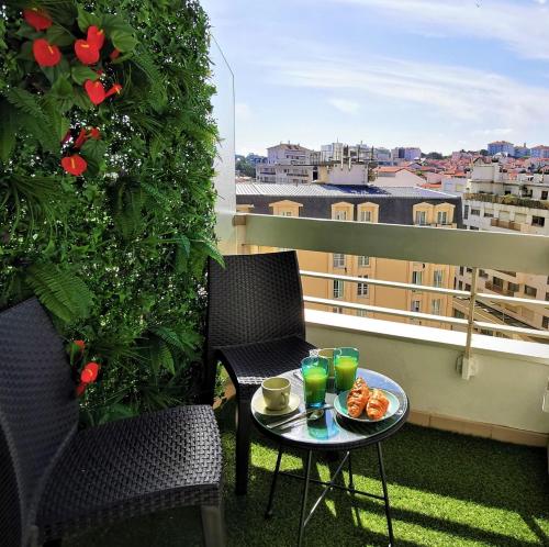 a balcony with two chairs and a table with drinks at Studio AppartHôtel OCEAN 7, Plage, Piscine, Terrasse in Biarritz