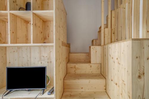 Cette chambre dispose de murs en bois, d'escaliers et d'une télévision. dans l'établissement Studio Cardinal - Studio mezzanine refait à neuf proche de la gare, à Annecy