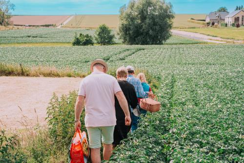 a group of people walking through a field at Cour 44 - Gite de charme avec sauna et jacuzzi in Remicourt