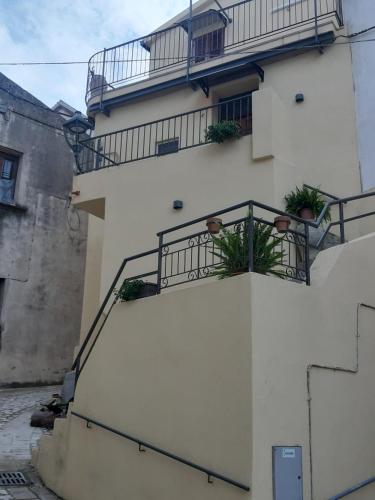 ein weißes Gebäude mit einem Balkon mit Pflanzen in der Unterkunft b&b casa vacanze Rebi house in San Giorgio Albanese