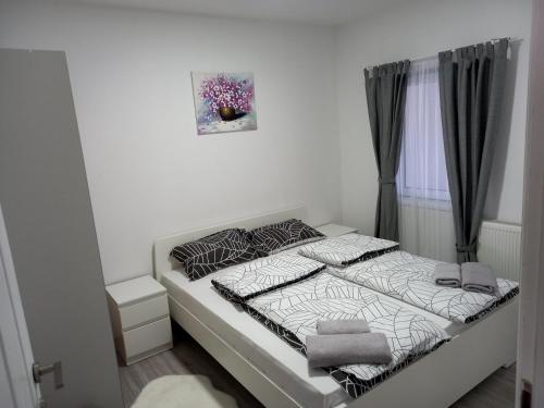 niewielka sypialnia z łóżkiem z białą pościelą w obiekcie Apartmani Dubrava 1 w Zagrzebiu
