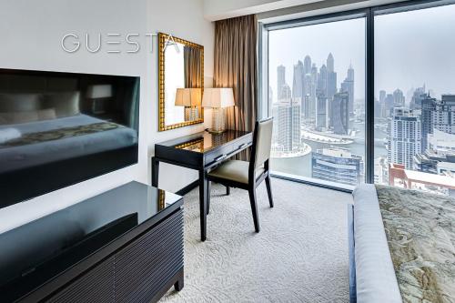 a hotel room with a bed and a desk and a window at Marina Mall Apartments, Dubai Marina in Dubai