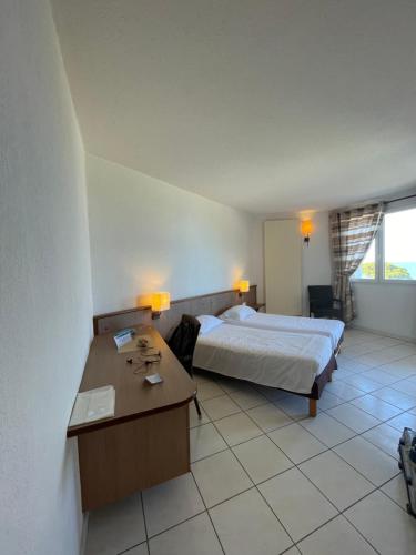 a hotel room with a bed and a desk at Le Village des Isles in Taglio-Isolaccio