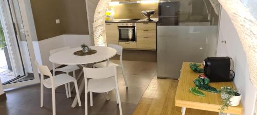 a kitchen with a white table and chairs in a kitchen at BorgoAntico34 - Luxury Room in Molfetta